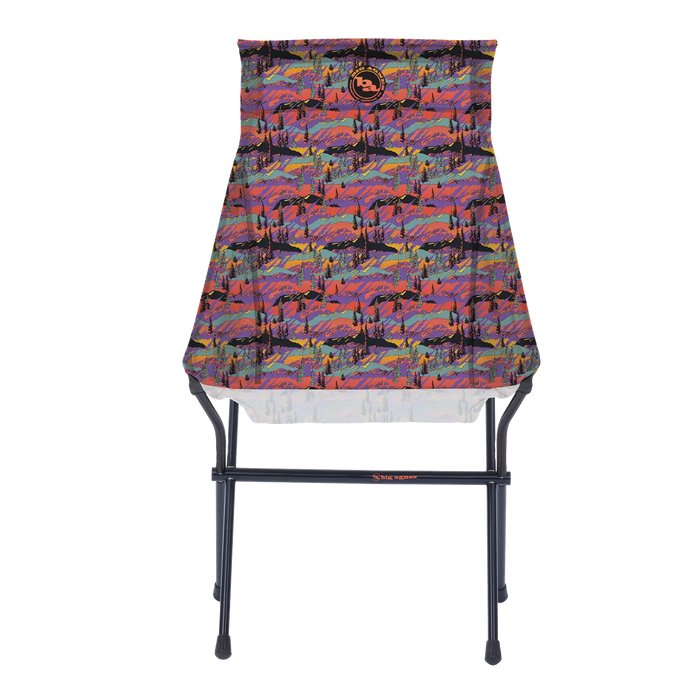 The Big Agnes Big Six Camp Chair - Alpenglow is a lightweight, packable camp chair with a black metal frame and a colorful seat featuring a vibrant abstract mountain landscape in red, purple, blue, and orange.