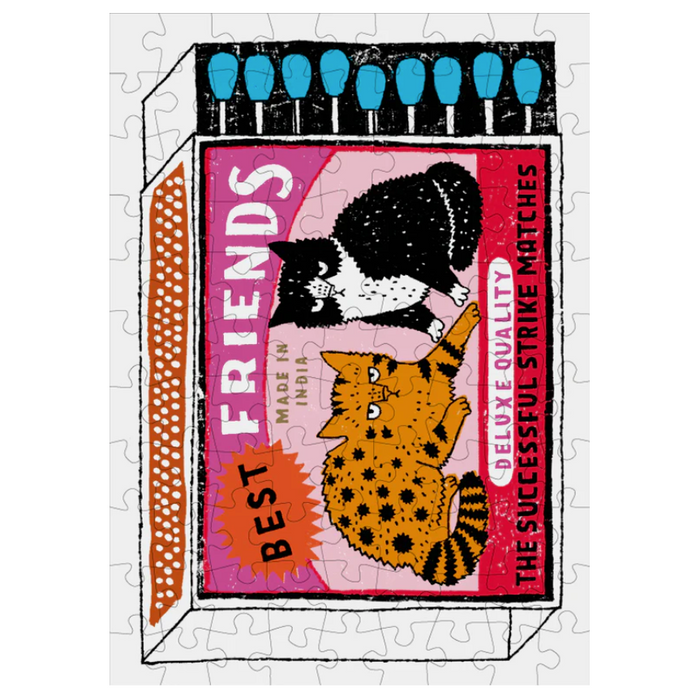 Jigsaw puzzle with a design of two cats on a matchbox labeled 'Friends' on a white background.