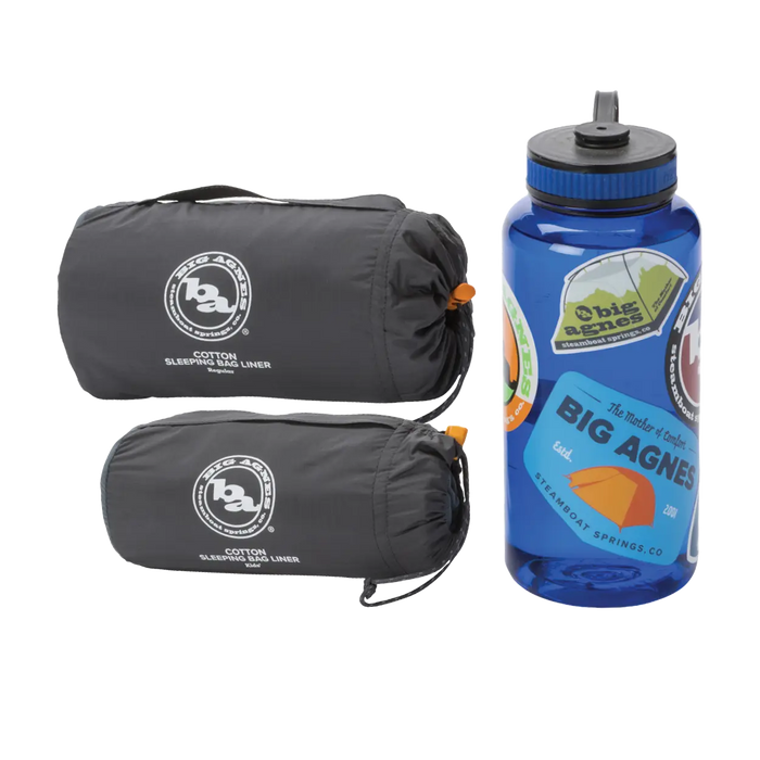Two rolled-up Big Agnes Cotton Sleeping Bag Liners in gray are placed beside a blue water bottle with vibrant outdoor-themed stickers—ideal companions for your next adventure.