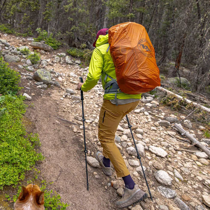 Person hiking on a trail with a large orange backpack