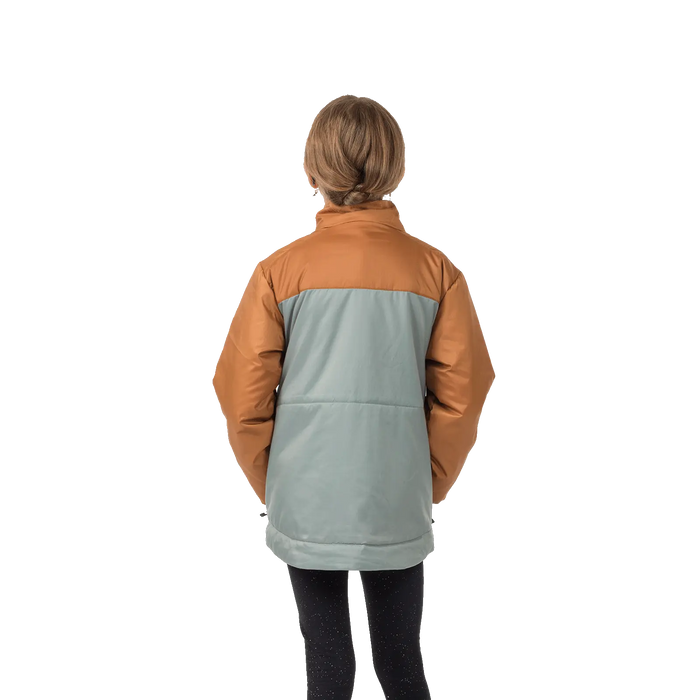 A child with light brown hair stands facing away in a Big Agnes Kids' Flapjack Jacket and black speckled leggings, set against a plain white background.