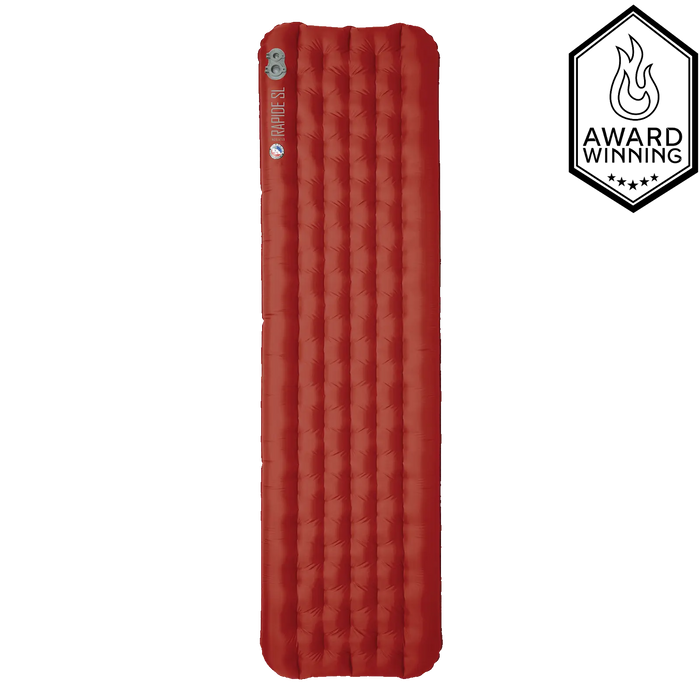 A red Big Agnes Rapide SL Insulated sleeping pad stands vertically on a white background, featuring a top-left integrated valve and small logo. A badge on the right displays "Award Winning" with a flame icon and five stars.