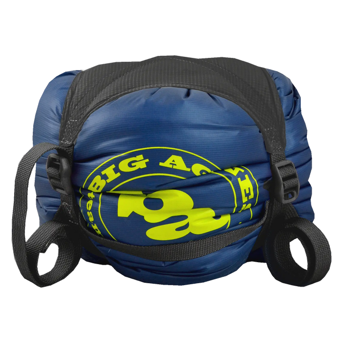 A blue and yellow Big Agnes Superlight Girdle with black straps is cinched tightly on a white background—ideal for compressing your sleeping bag and streamlining gear storage.