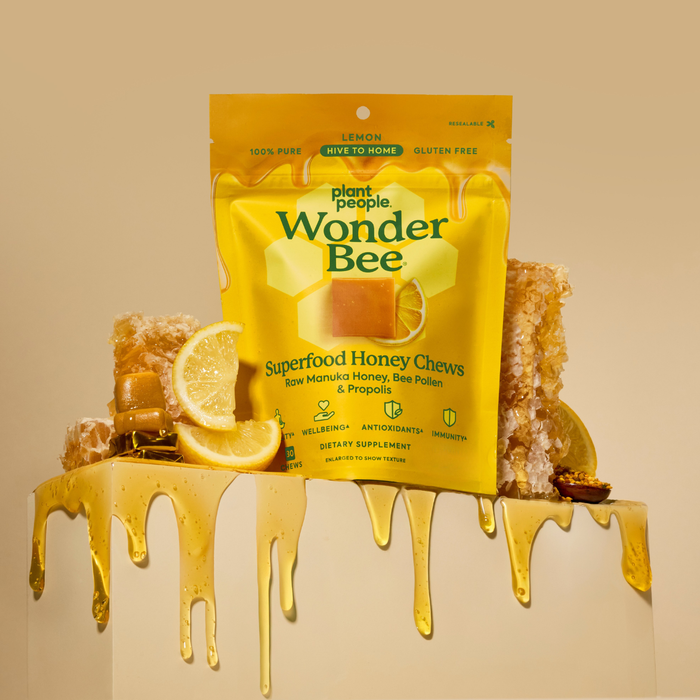 Packaging of Wonder Bee Superfood Honey Chews with honey and lemon slices on a beige background