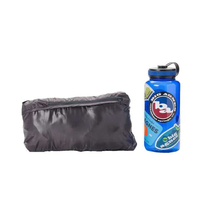 A compact, gray W's Larkspur Vest by Big Agnes sits beside a blue stickered water bottle on a white background, showcasing the vest's small and portable size.